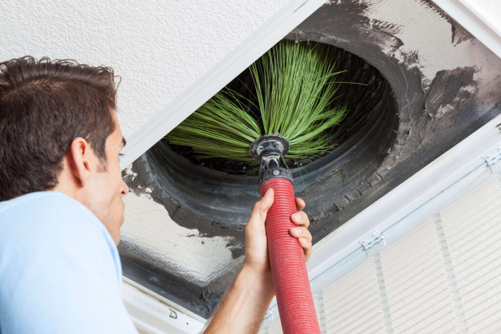 Close up of tech cleaning air duct